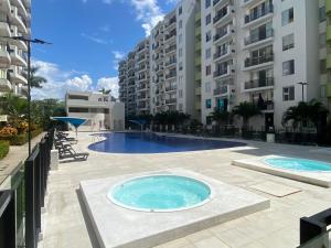 une grande piscine avec deux grands bâtiments dans l'établissement Apartamento en Ricaurte - Reserva de Peñalisa, à Ricaurte