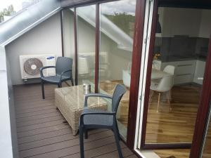 a balcony with a table and chairs and a kitchen at Napoleon Hill Apartment in Kaunas +16 photos