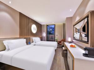 Rúm í herbergi á Crystal Orange Hotel Shanghai Hongqiao Jinhui Road