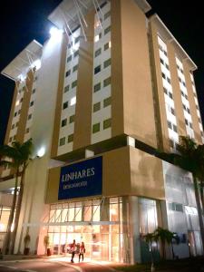 リニャレスにあるLinhares Design Hotel LCの大きな建物とその前を歩く人々