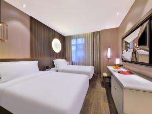 Rúm í herbergi á Crystal Orange Hotel Shanghai Hongqiao Jinhui Road