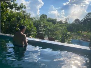 a man is standing in a swimming pool at Green Bamboo Lodge Resort in Cat Tien