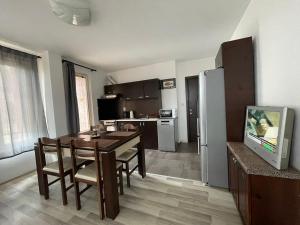 a living room with a dining room table and a kitchen at Adagio Sarafovo in Burgas