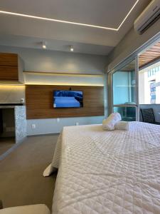 una camera da letto con un letto grande e una TV a schermo piatto di Apart-Hotel Costa Mar - luxo- beira mar a Recife