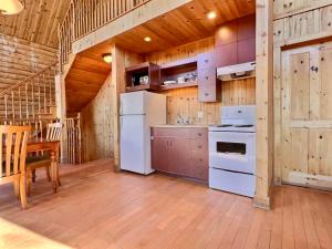 a kitchen with white appliances and a wooden ceiling at Domaine Appalaches 30 Incredible view in Saint-Paul-de-Montminy