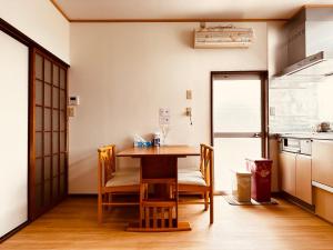 a kitchen with a table and chairs in a room at Urasa cottage at the station in Minami Uonuma