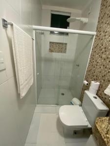 a white bathroom with a shower and a toilet at Cantinho da Barra in Barra dos Coqueiros
