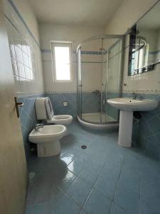 a bathroom with two toilets and a shower and a sink at B&B - Private rooms 3 in Tirana +14 photos