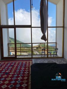 a room with a large window with a view of a mountain at Penginapan Homestay Sikunir - Bukit Bintang Dusun Musilan in Kejajar