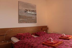 ein Schlafzimmer mit einem roten Bett mit zwei Handtüchern darauf in der Unterkunft Casa Micheroli in Gordola