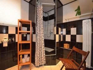 Wohnung Steinbach nahe Skihalle Oberhof, cleaning included في Kurort Steinbach-Hallenberg: حمام مع دش وكرسي خشبي +18 صورة