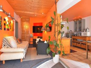 Wohnung Steinbach nahe Skihalle Oberhof, cleaning included في Kurort Steinbach-Hallenberg: غرفة معيشة مع جدران برتقالية وأريكة