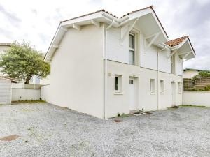 a white house with a parking lot at Maison T3, proche océan et centre, terrasse privative, parking, 300m plage - Biscarrosse Plage - FR-1-521-31 in Biscarrosse-Plage +2 photos