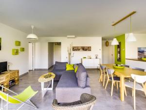 un soggiorno con un divano blu e un tavolo di Maison contemporaine Biscarrosse, 7 pers., 3 ch., Wi-Fi, sur terrain 700m², proche activités et plages - FR-1-521-44 a Biscarrosse