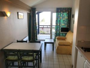 a living room with a table and a couch at Appartement avec Terrasse et Piscine à Guéthary, Proche Plages - FR-1-239-604 in Guéthary