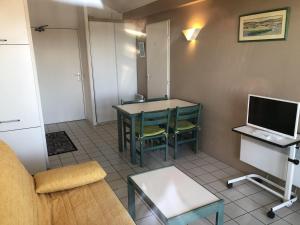 a living room with a couch and a desk with a computer at Appartement avec Terrasse et Piscine à Guéthary, Proche Plages - FR-1-239-604 in Guéthary