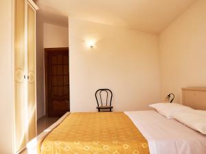 1 dormitorio con 1 cama y 1 silla en Goritto, en Dorgali