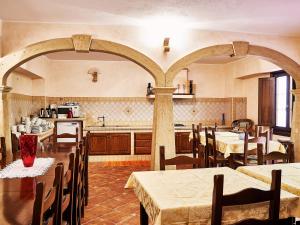 kuchnia i jadalnia ze stołami i krzesłami w obiekcie Goritto w mieście Dorgali