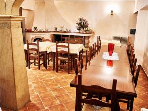 a dining room with tables and chairs and a fireplace at Goritto in Dorgali