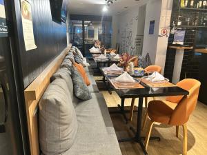 a row of tables in a restaurant with a couch at TOP quarto Stay Inn hotel 3 min Av Paulista in Sao Paulo