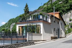 a house with a balcony on the side of a mountain at Residenza Decimina in Varenna