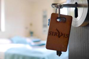 a tag hanging from a door in a room at Sirvis Apartamenty in Płaska