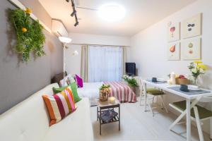 a small living room with a white couch and a desk at Home Tokyo Takinogawa in Tokyo