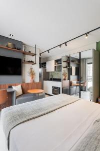 a bedroom with a large white bed and a living room at Luxo e Conforto na Melhor Localização do Centro in Curitiba +32 photos