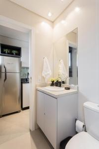 a kitchen with a sink and a refrigerator at Luxo e Conforto na Melhor Localização do Centro in Curitiba