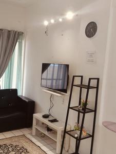 ein Wohnzimmer mit einem Fernseher an der Wand in der Unterkunft PD Seaview Corus Paradise Lagoon in Port Dickson