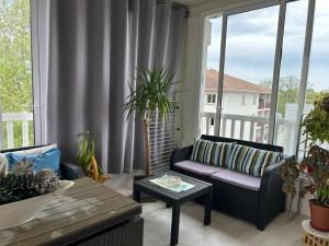 un salon avec un canapé et une table dans l'établissement Charmant appartement à Ondres pour 4 pers. avec loggia et parking - FR-1-239-1116, à Ondres