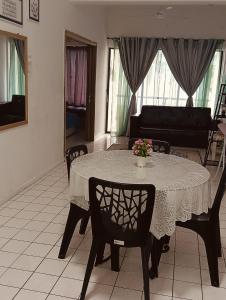 ein Esstisch mit einer Vase mit Blumen darauf in der Unterkunft PD Seaview Corus Paradise Lagoon in Port Dickson