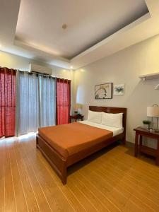 a bedroom with a large bed and red curtains at Nadelmar Hotel and Resort in Dalaguete +44 photos