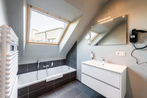 a bathroom with a sink and a tub and a window at Smartflats Design - Berlaymont in Brussels