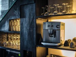 a kitchen with a coffee maker and glasses on shelves at Villa Mana by Elite Havens in Canggu