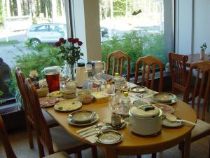 a wooden table with plates and dishes on it at Huoneistohotelli Teekki in Muuruvesi