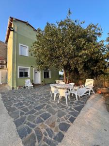a patio with white chairs and a table and a tree at Casa Chao in Estopiñán +34 photos