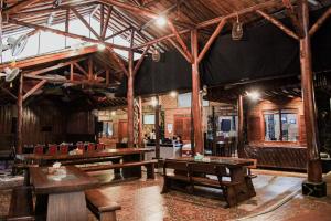 a large room with wooden tables and benches at Saung Dolken Syariah Resort & Hotel in Sukaraja