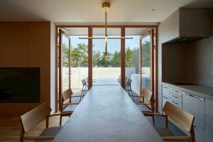 a long dining room with a long table and chairs at Villa NIGIN in Miyazu