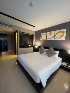 a large white bed in a room with two lamps at Beachfront Deluxe BR Infinity Pool Patong Phuket in Patong Beach
