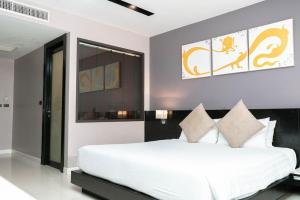 a bedroom with a large white bed with pillows at Beachfront Deluxe BR Infinity Pool Patong Phuket in Patong Beach