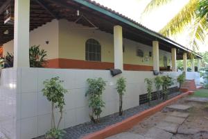 een gebouw met een rij bomen ervoor bij Sítio em Barra de Jacuípe in Camaçari