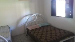 een klein bed in een hoek van een kamer bij Sítio em Barra de Jacuípe in Camaçari