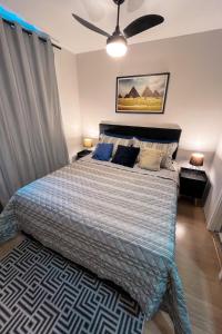 a bedroom with a bed and a ceiling fan at MV 135A Studio 135, com AR Condicionado a 50 mts do METRÔ Brás Rua Coronel Mursa, 56 in Sao Paulo