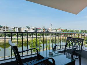 a balcony with two chairs and a table with a view at Khách Sạn Sông Lô in Hải Dương