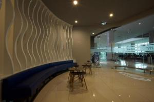 a lobby with chairs and tables in a building at Passgo Digital Airport Terminal 3 Soekarno Hatta in Tangerang