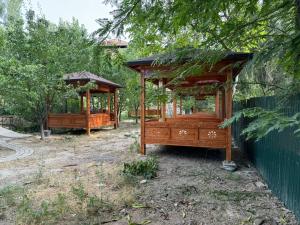 a wooden bed and a gazebo in a yard at Lovely home shatry in Osh +12 photos