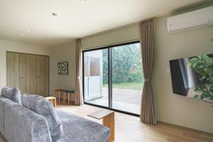 a living room with a couch and a large window at Green Peak 1 in Aso +24 photos