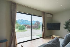 a living room with a large window with a view at Green Peak 1 in Aso