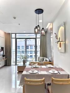 a dining room and living room with a table and chairs at LUNA Apartment - Luxury Residence Landmark 81 Area in Ho Chi Minh City
